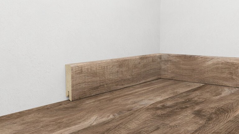 Holzfußbodenoptik mit Holzsockelleiste in Ecke.